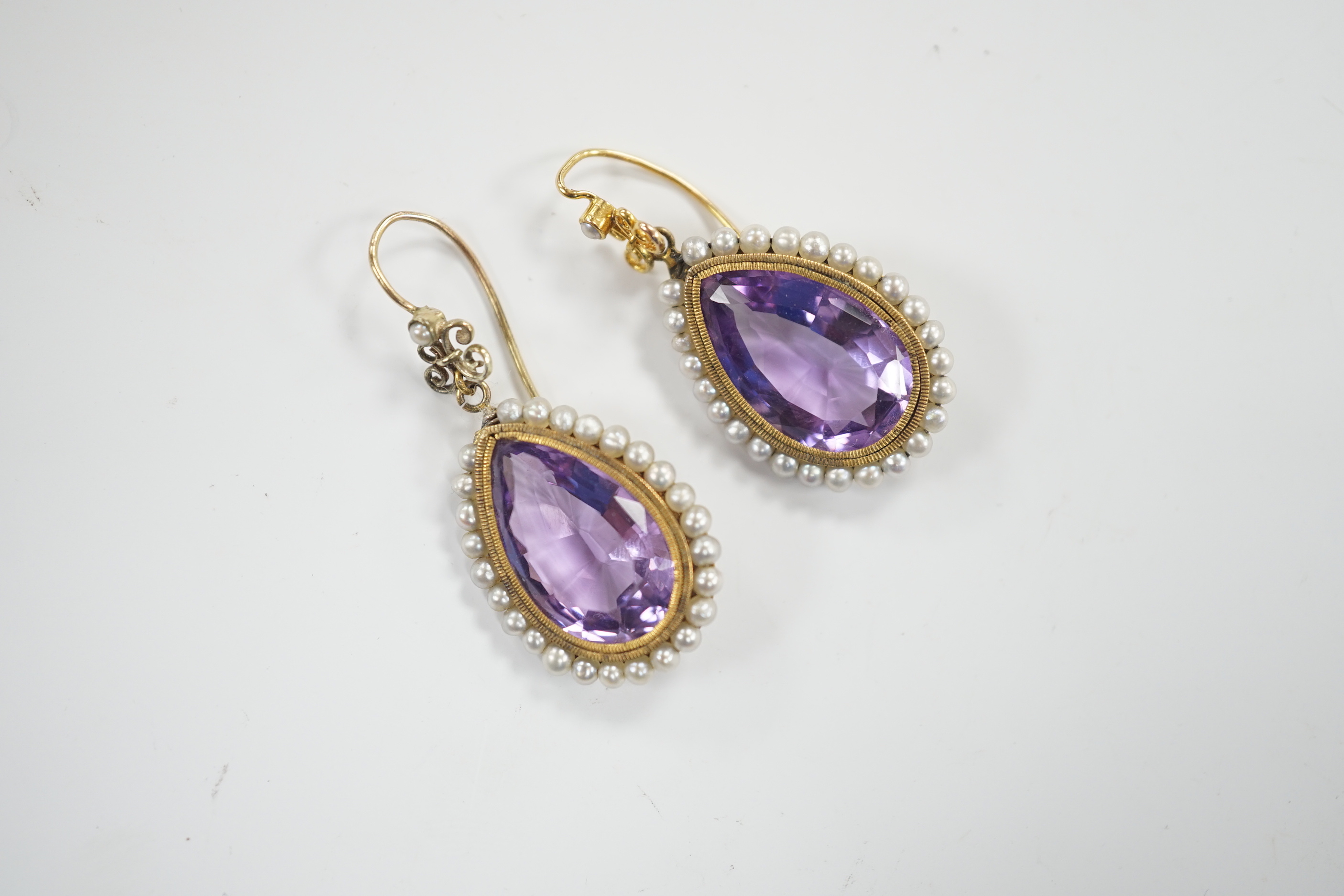 A pair of Victorian yellow metal, amethyst and seed pearl set teardrop shaped drop earrings, 21mm, gross weight 5.5 grams.